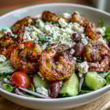 A vibrant Greek Shrimp Bowl garnished with fresh herbs, ready to serve with warm pita or crisp white wine.