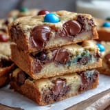 Chewy cookie bars with Cadbury mini eggs and pastel M&Ms, baked to golden perfection for spring celebrations.  
