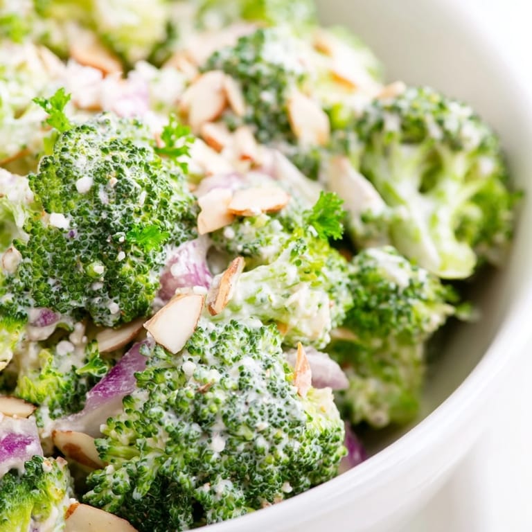 Vibrant Garlic Parmesan Broccoli Salad plated as a light lunch, garnished with parsley and extra Parmesan cheese.