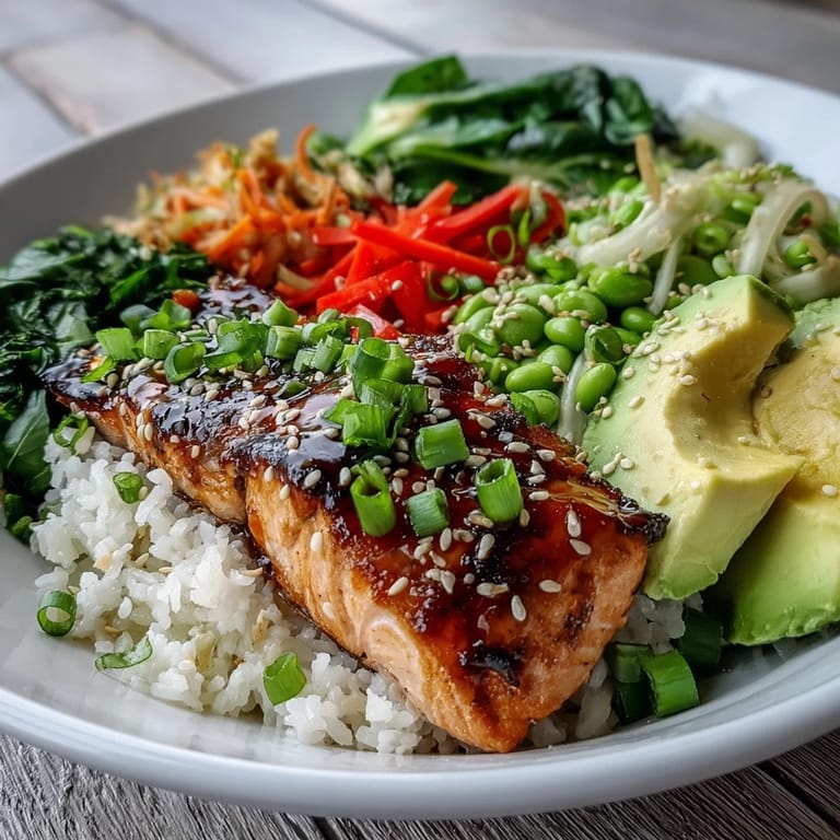 Fresh stir-fry vegetables and tender salmon over fluffy rice, garnished with sesame seeds and green onions in a bowl.